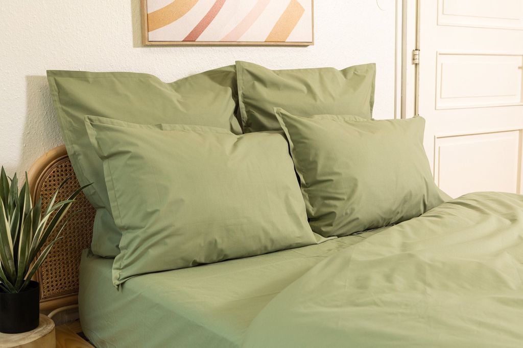 Housse de couette Mello en percale kaki sur un lit à tête de lit en rotin