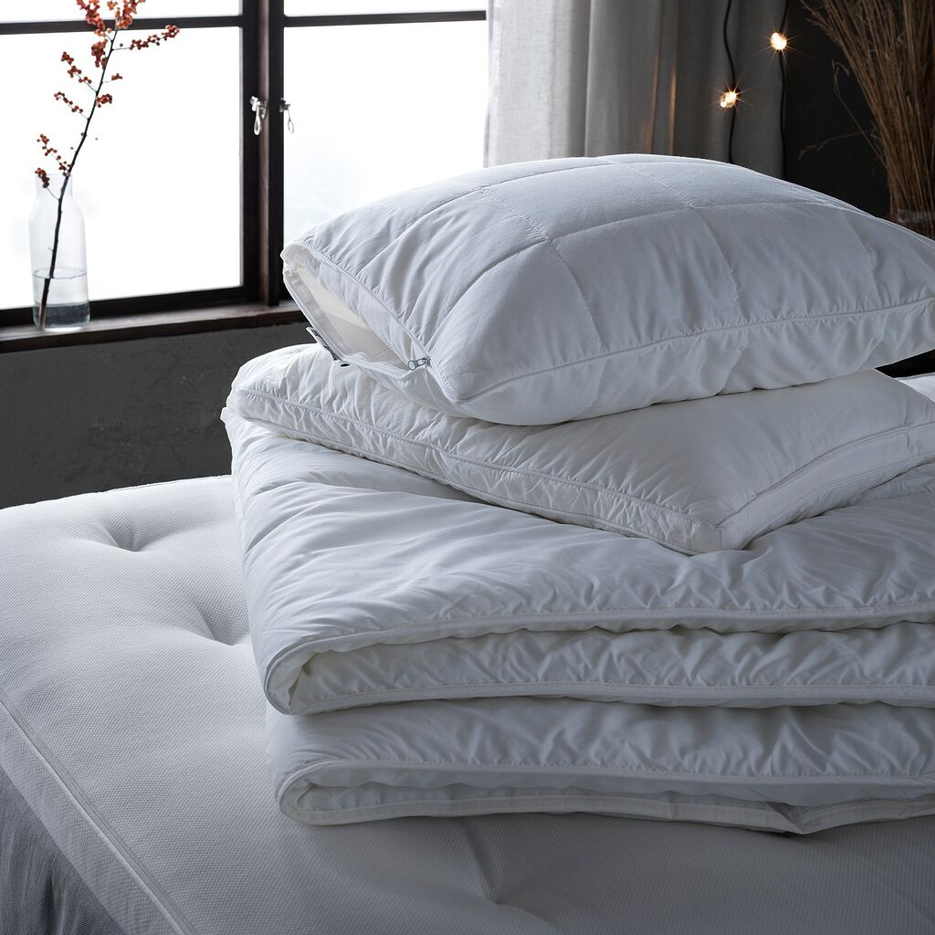 Oreillers et couette IKEA posés sur un matelas dans une chambre