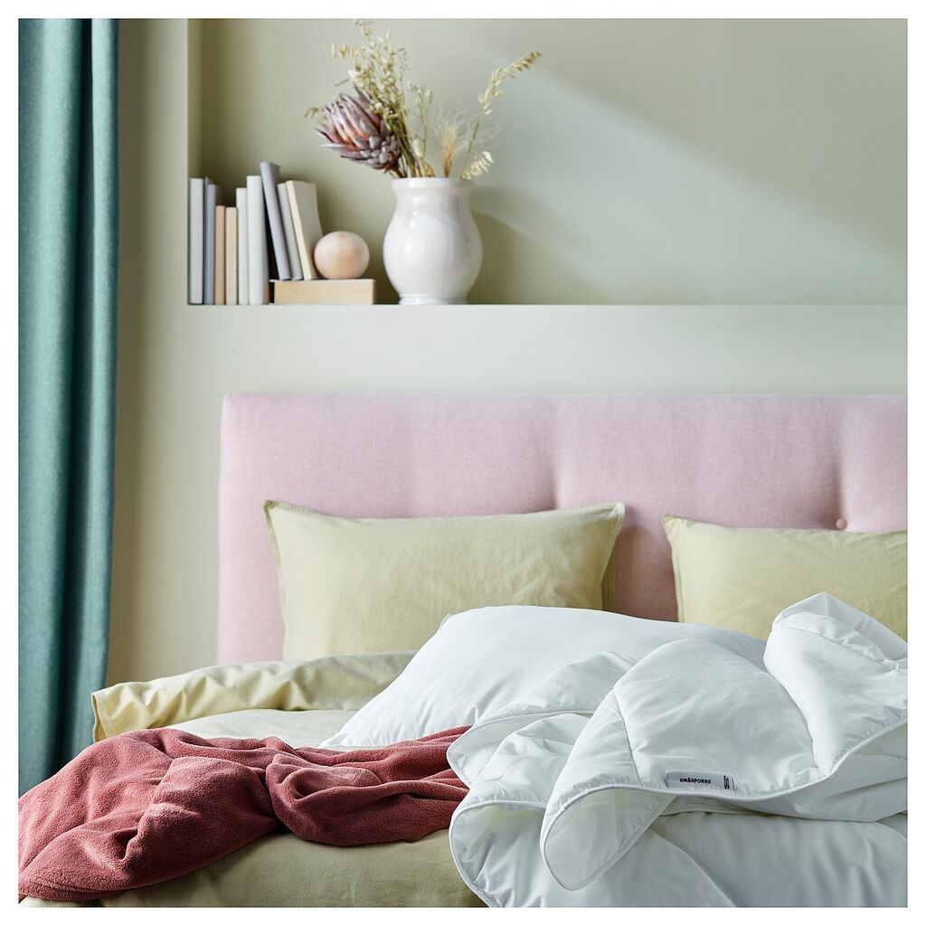 Couette IKEA SMÅSPORRE toutes saisons sur un lit avec tête de lit rose