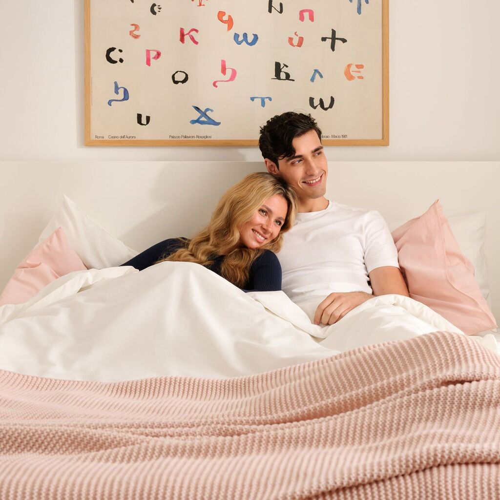 Couple au lit sous la couette, réchauffé par un chauffe-lit Imetec Adapto
