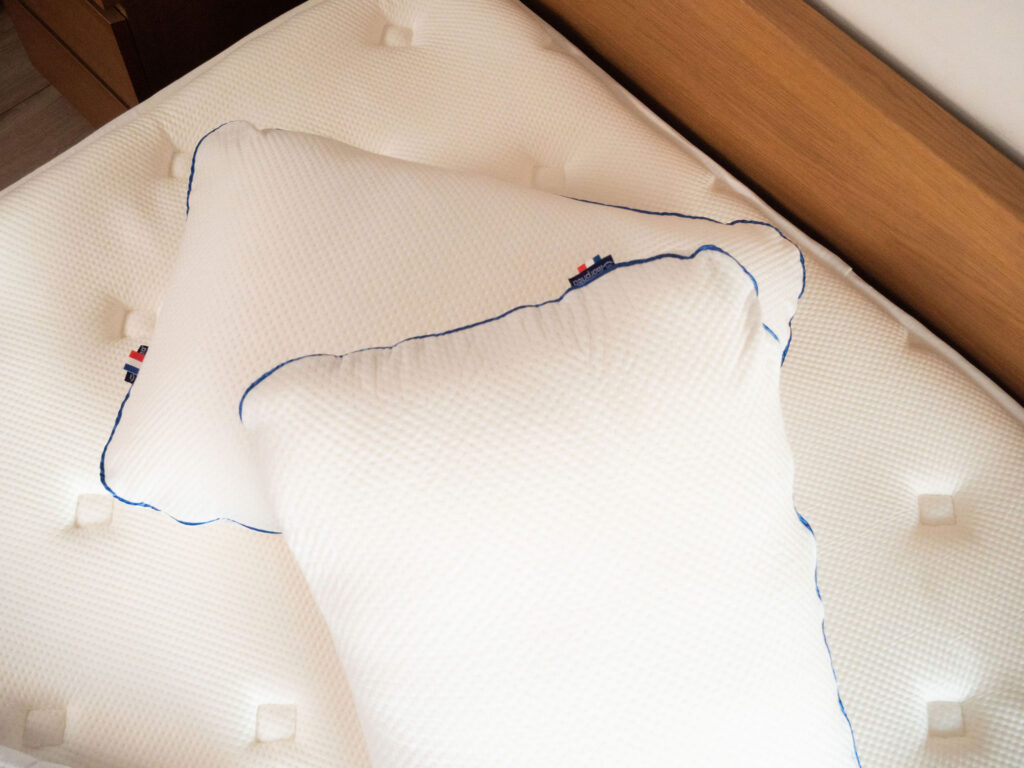 Deux oreillers Morphea Memory Air avec leur biais bleu sur un matelas