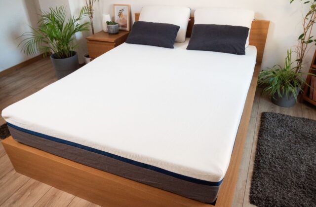 Lit en chêne avec matelas, plantes et tapis, vue en hauteur