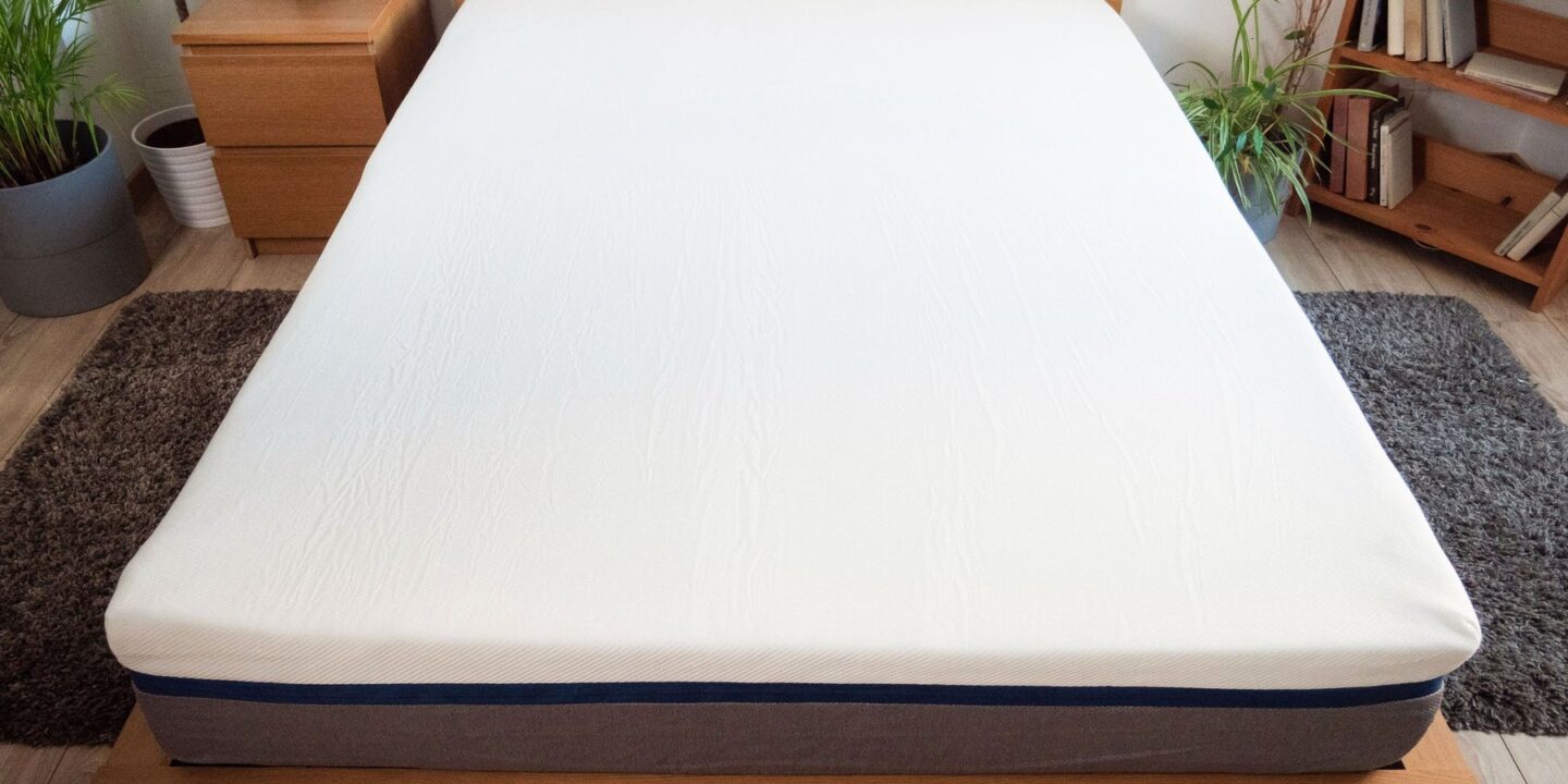 Matelas sur un lit en chêne vu depuis le pied du lit