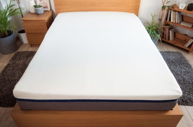 Matelas sur un lit en chêne vu depuis le pied du lit