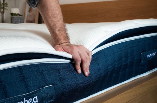 Main appuyant sur le bord d'un matelas pour tester sa fermeté