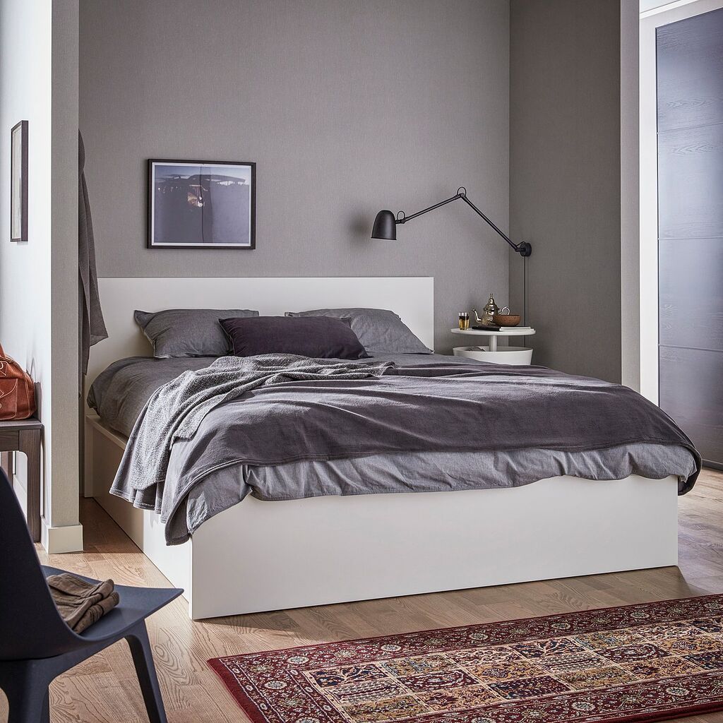 Lit coffre IKEA MALM blanc dans une chambre aux murs gris