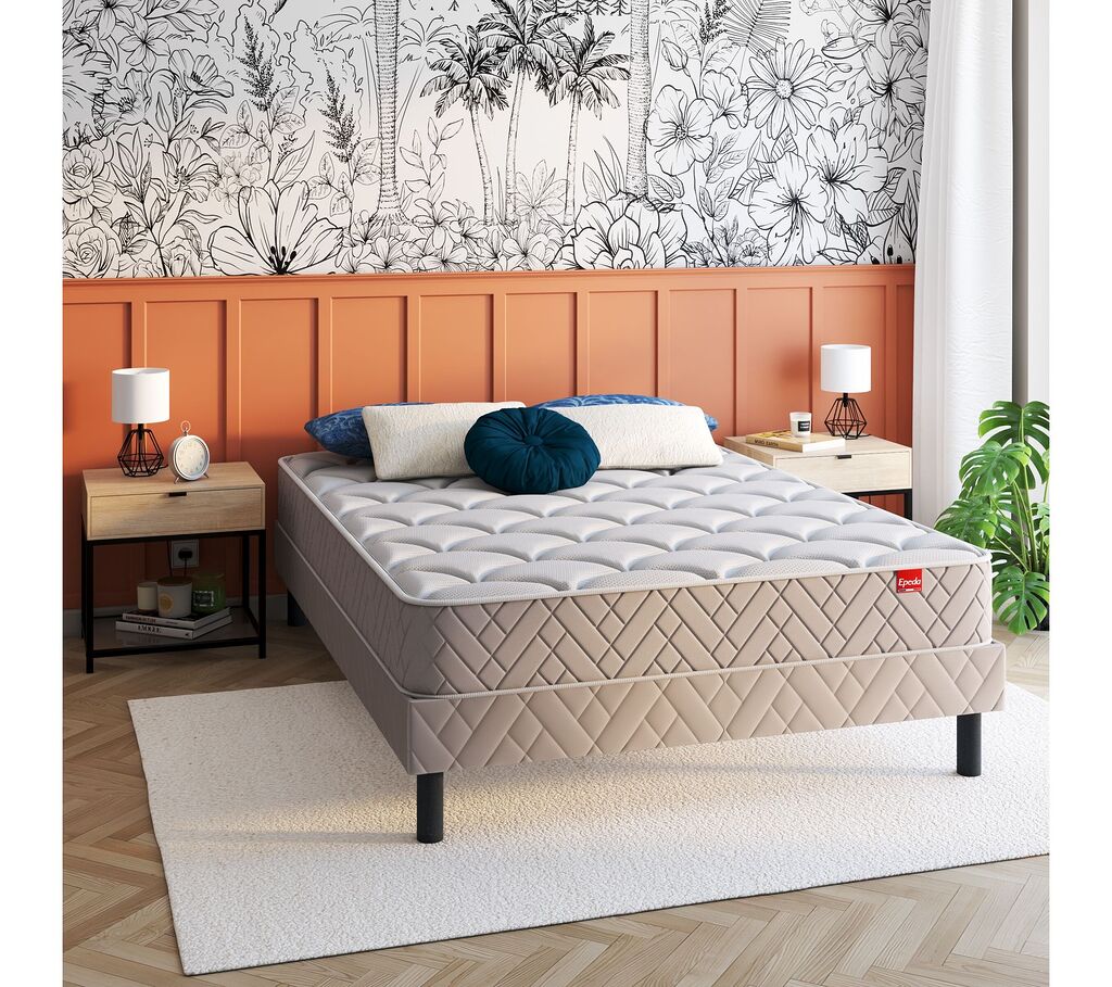 Matelas Épéda Bomba Top sur un sommier dans une chambre au papier peint végétal