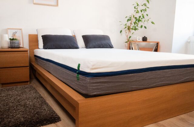 Vue latérale d'un matelas avec oreillers sur un lit en chêne