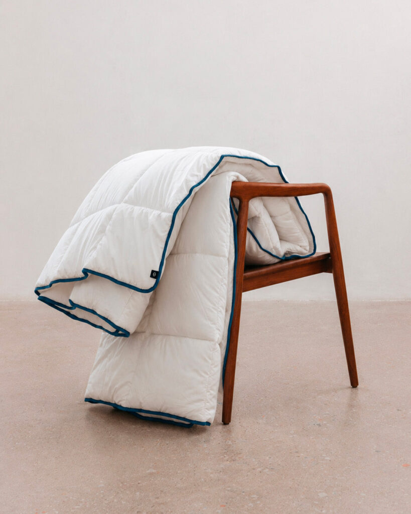 Couette tempérée Morphea pliée sur une chaise en bois