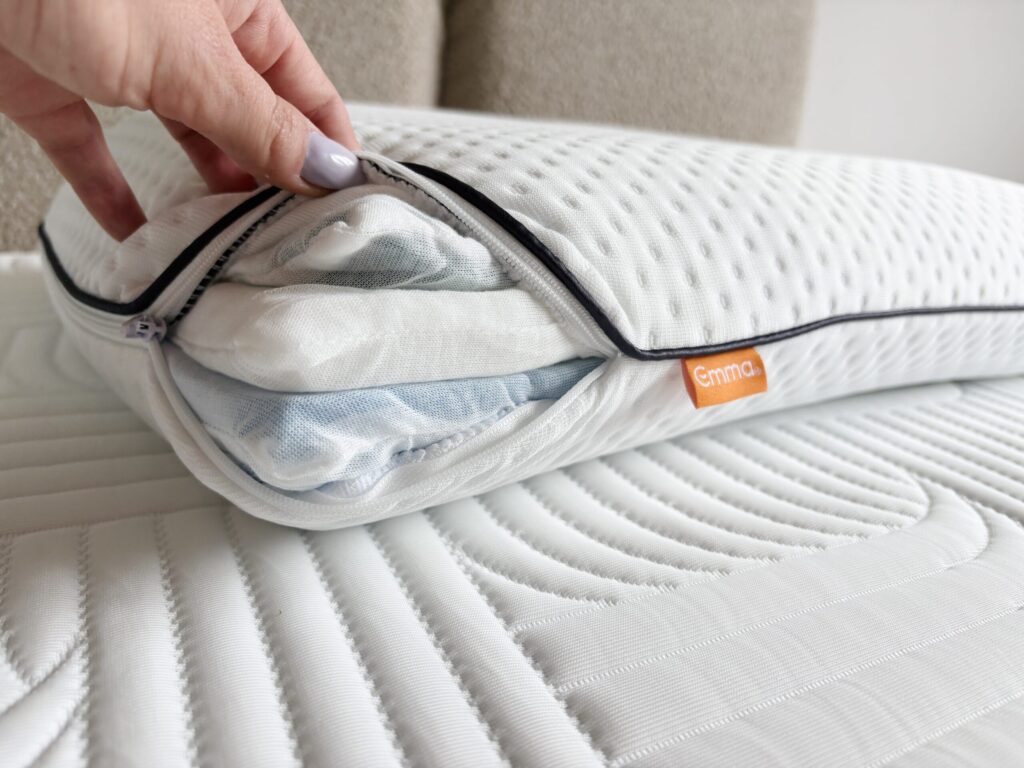 Main ouvrant la fermeture de l'oreiller Emma Adapt Thermorégulant
