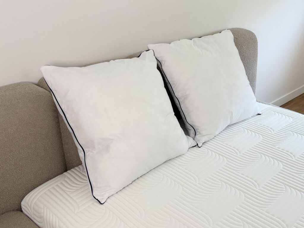 Deux oreillers Emma Original Confort sur un matelas blanc, vue de trois quarts