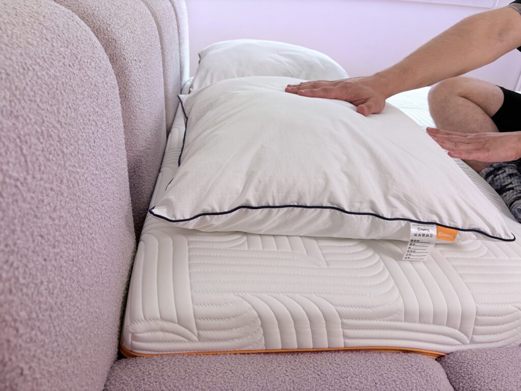 Main appuyant sur l'oreiller Emma Original Confort pour tester son moelleux