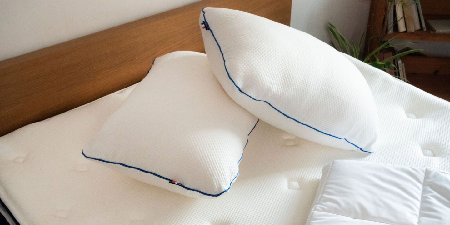 Deux oreillers et une couette pliée sur un matelas