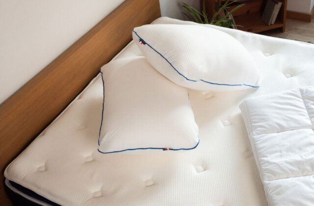 Un oreiller rectangulaire et un oreiller carré posés sur un matelas, photographiés pendant notre test