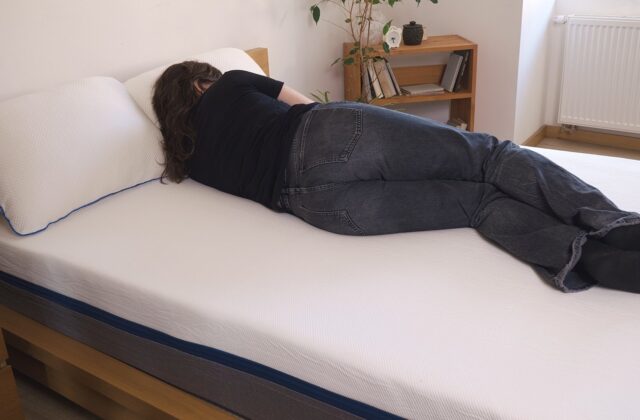 Personne allongée sur un matelas blanc dans une chambre