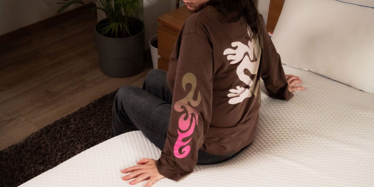 Personne assise sur le lit au réveil, regardant derrière elle