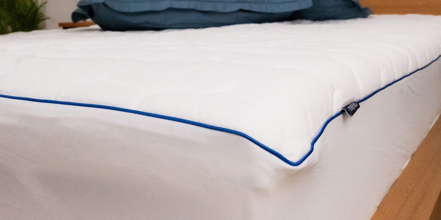 Protège-matelas blanc à passepoil bleu marine avec oreillers bleus