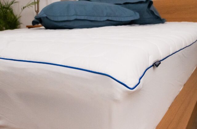 Protège-matelas blanc à passepoil bleu marine avec oreillers bleus