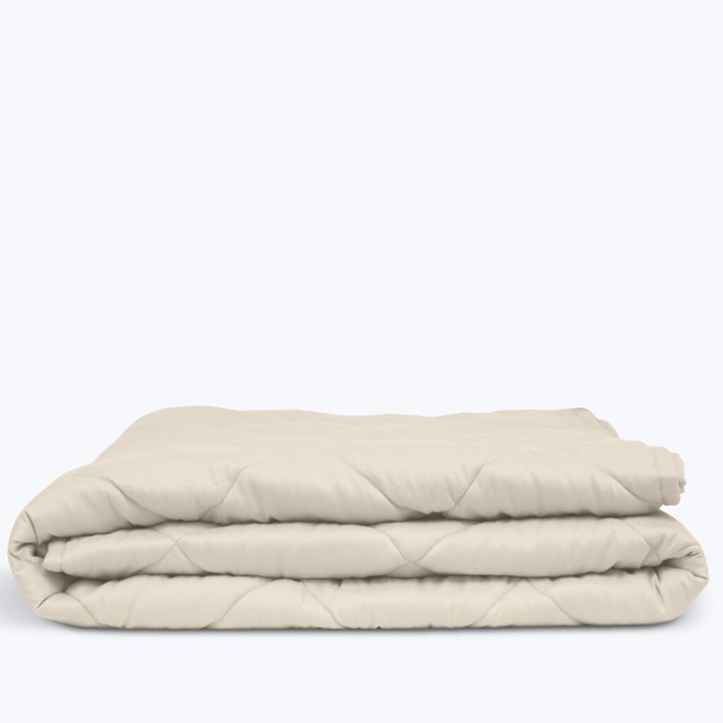 Couverture lestée Slome coloris beige pliée sur fond blanc