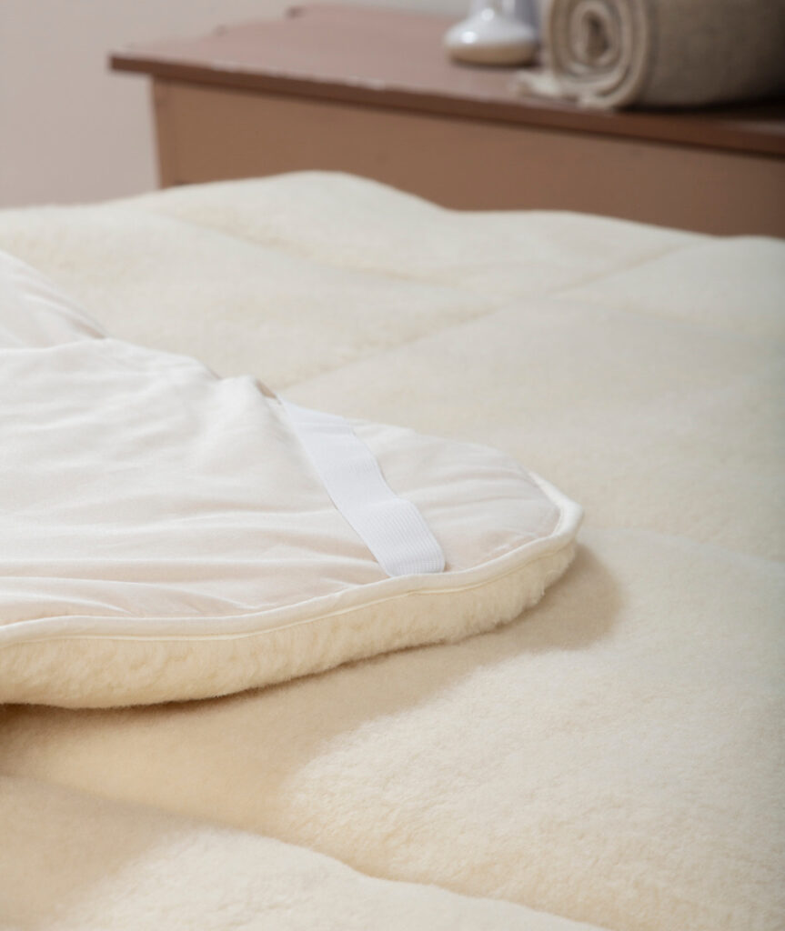 Gros plan sur le velours de laine et l’élastique d’angle du surmatelas Ardelaine Confort