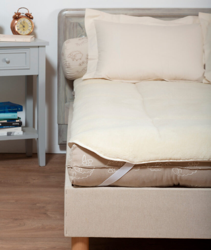 Angle du lit avec le surmatelas Ardelaine Confort en laine fixé par un élastique