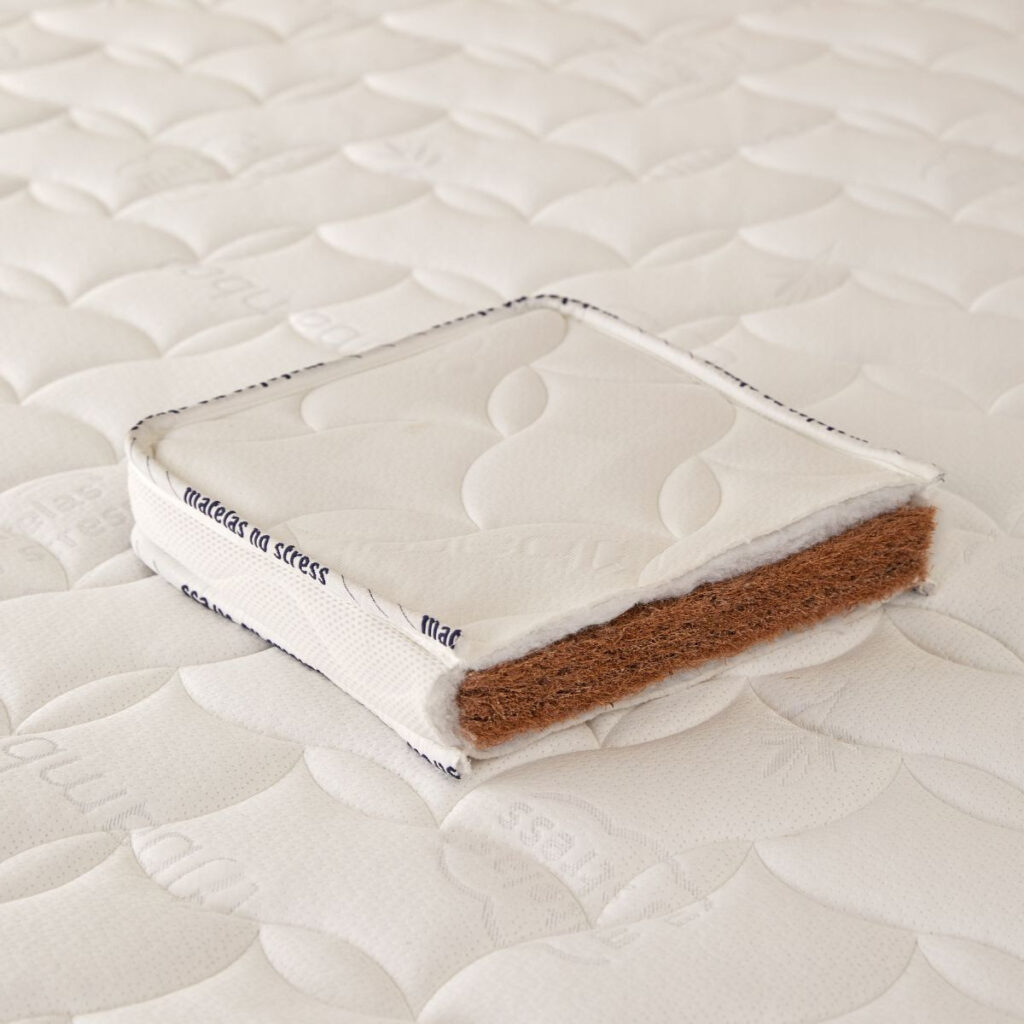 Coupe du surmatelas Matelas No Stress montrant l’âme en fibres de coco sous la housse