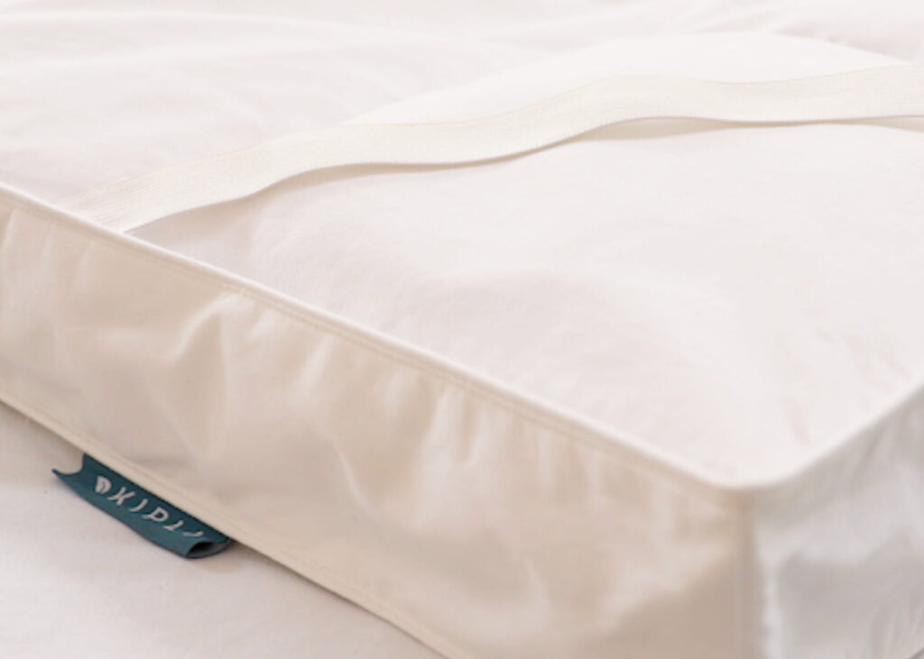 Angle du surmatelas Kipli avec son élastique et l'étiquette de la marque
