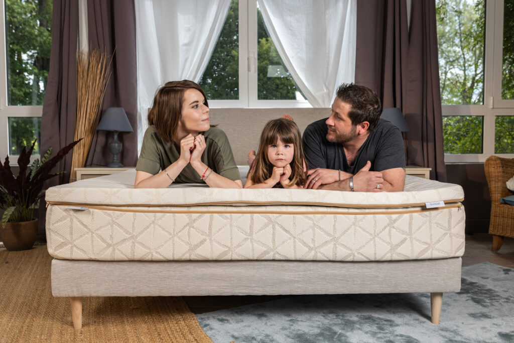 Famille allongée sur un lit équipé du surmatelas LatexBio