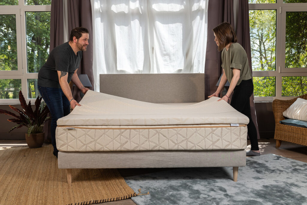 Couple installant le surmatelas latex naturel LatexBio sur un lit
