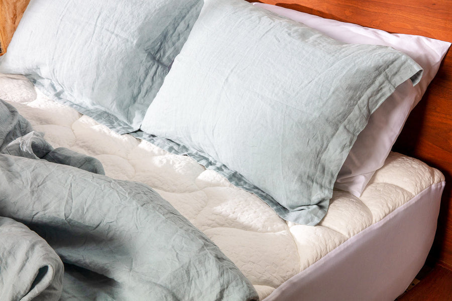 Surmatelas Mello Bambou sous des oreillers et une couette en lin