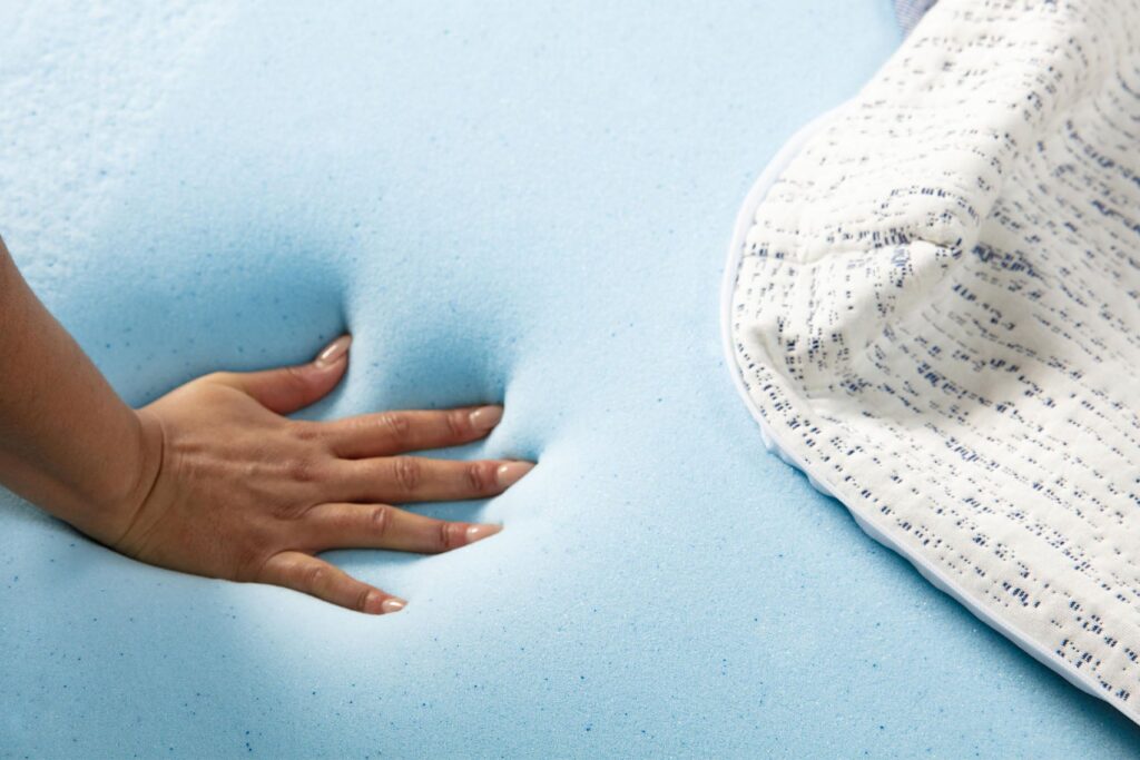 Main pressée dans la mousse à mémoire de forme infusée de gel du Mello Premium