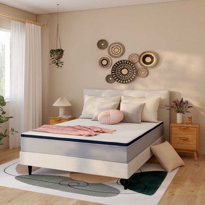 Surmatelas Nuit Faubourg Odéon posé sur un lit dans une chambre beige