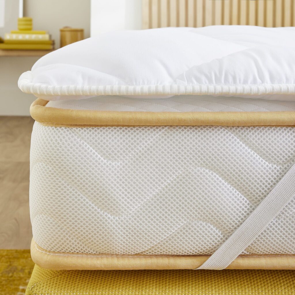 Angle du surmatelas Someo Ouate Aurore posé sur un matelas, avec son élastique de coin