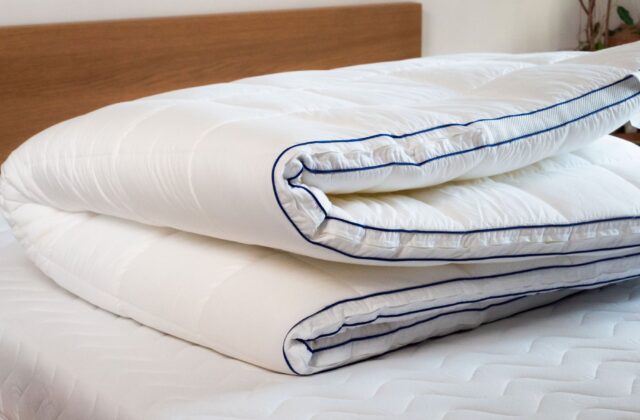 Surmatelas plié en trois posé sur un lit