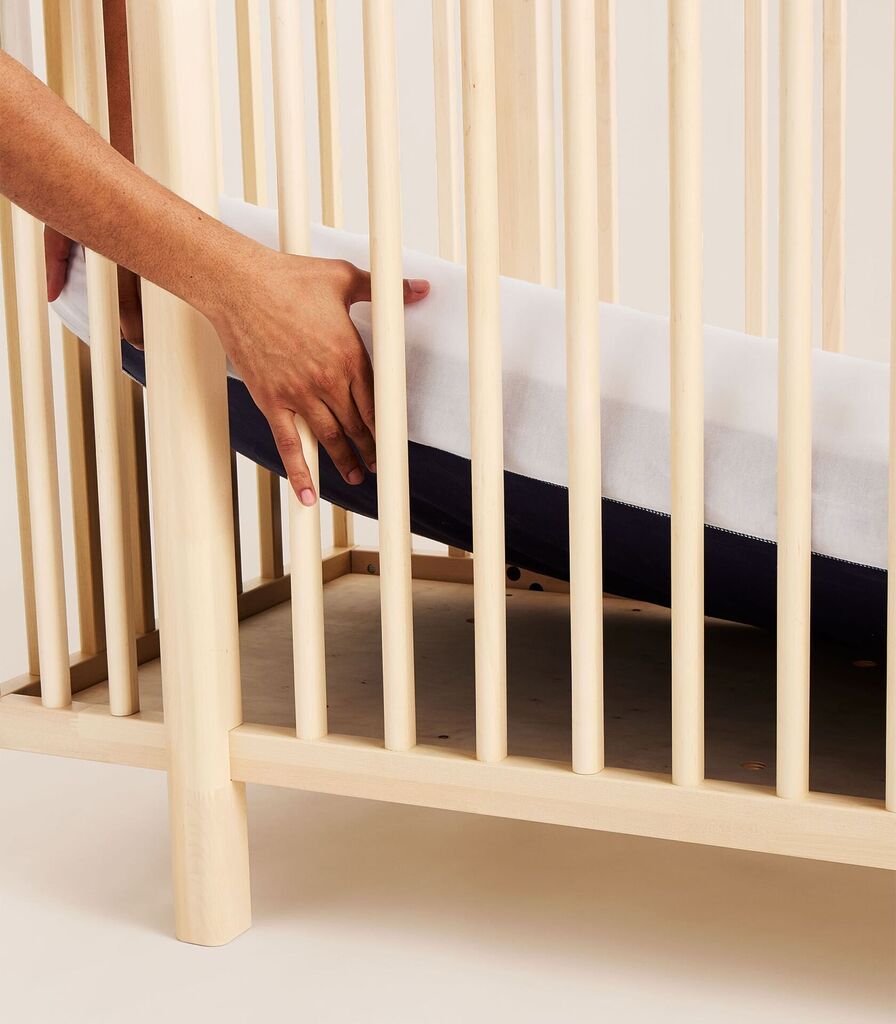 Matelas bébé Tediber Tedi glissé dans un lit à barreaux en bois