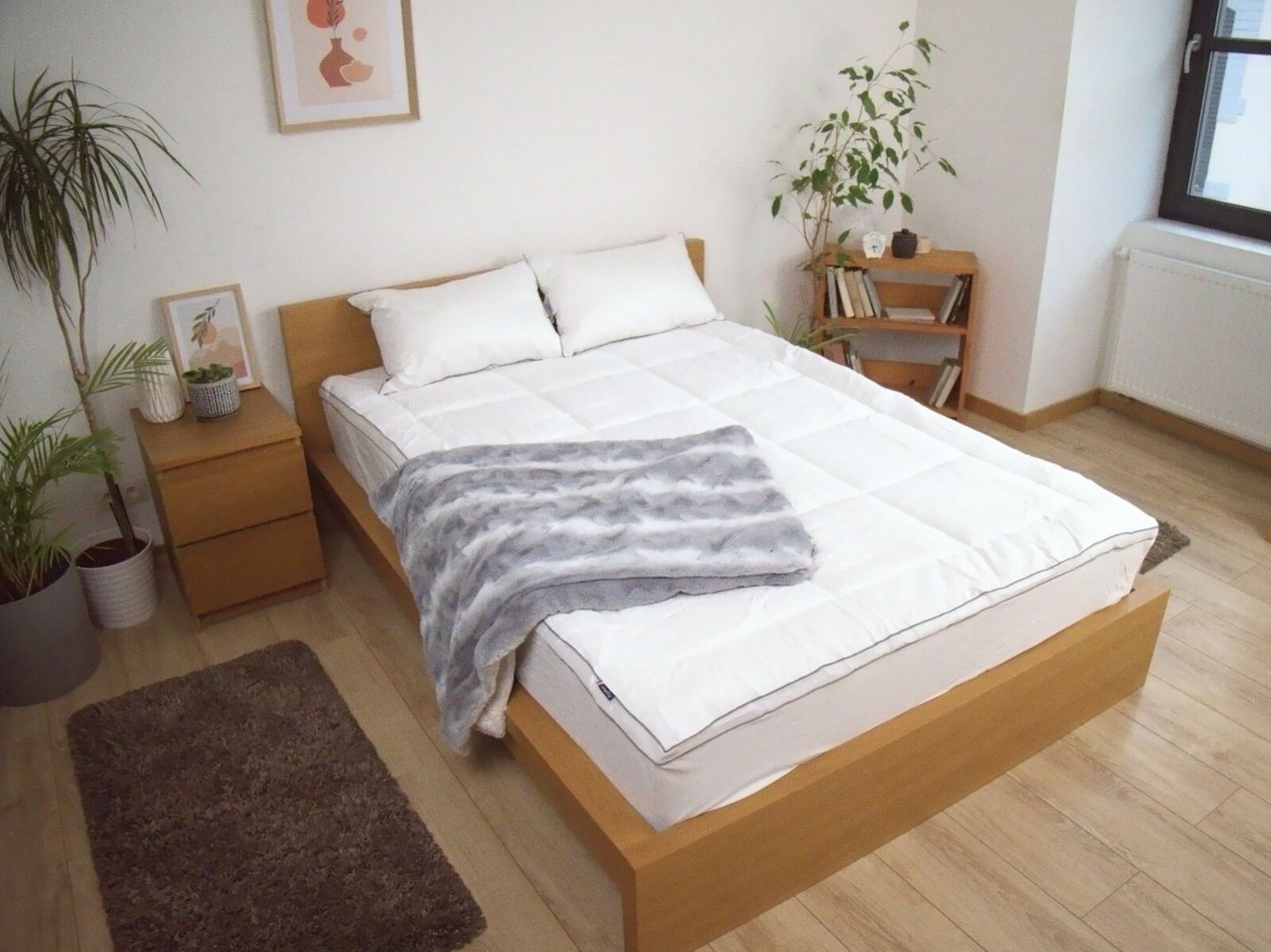 Surmatelas Mello Duo sur un lit en chêne avec plaid gris