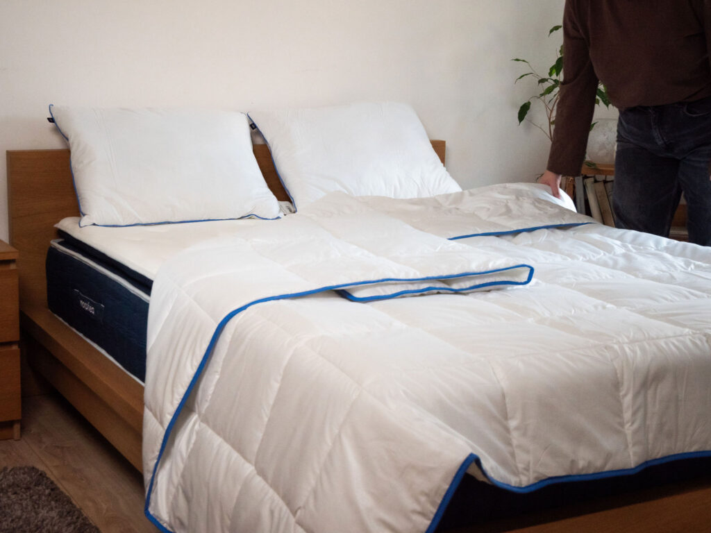 Couette tempérée Morphea sur le lit, testeur debout à côté