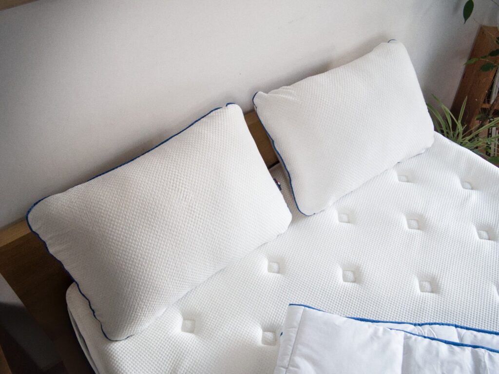 Oreillers Morphea Memory Air posés sur le lit, couette au pied