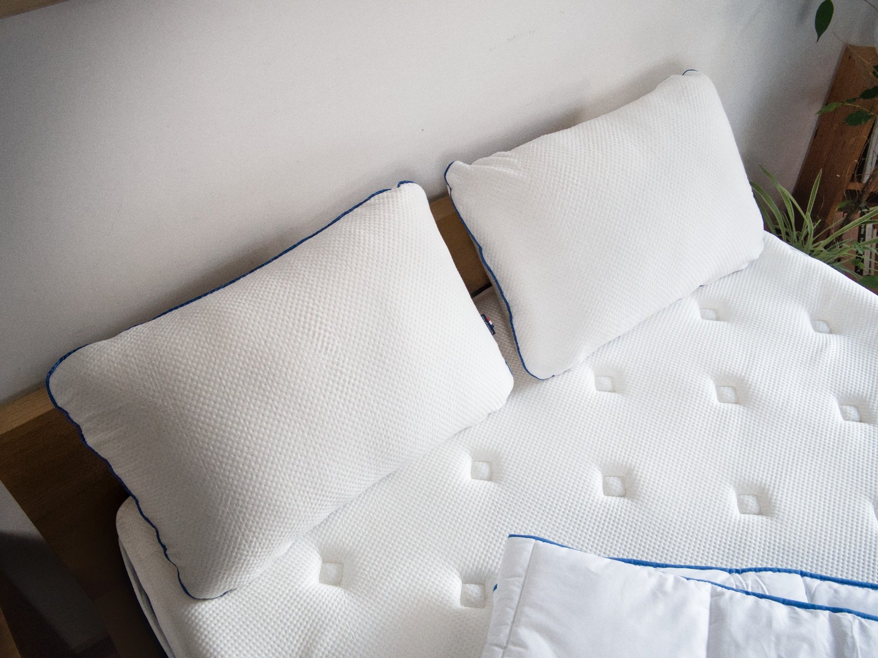 Oreillers Morphea Memory Air posés sur le lit, couette au pied