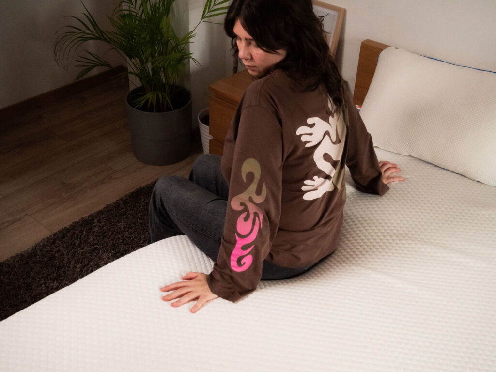 Testeuse assise sur le surmatelas Nyte Cosy