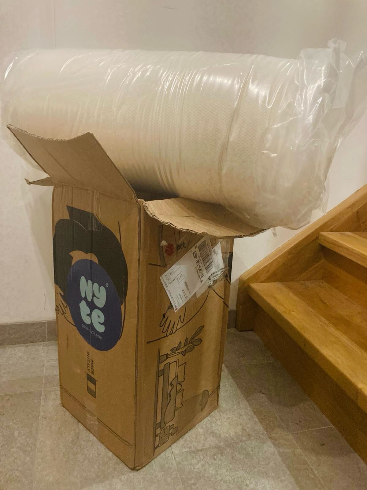 Surmatelas Nyte Cosy roulé sortant de son carton